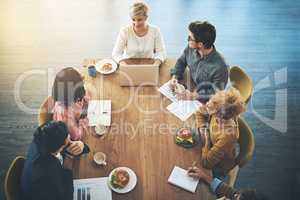 Considering everyones thoughts and ideas. High angle shot of a group of businesspeople having a meeting in an office.