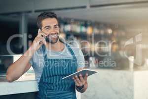 Yes, we do deliver. a young man using a digital tablet and mobile phone while working at a coffee shop.