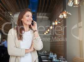 Customers keep calling to leave compliments about her business. a young entrepreneur talking on a cellphone in a cafe.