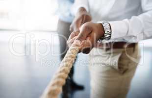 Just keep pulling once success is within your grasp. an unrecognizable businessman pulling on a rope during tug of war.