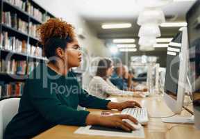 Shes a diligent student. a young female university student studying in the library.