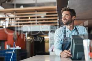 Making his coffeeshop dream come true. a young entrepreneur working in a cafe.