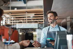 Excellent service is simply a part of the job. a waiter processing a credit card payment from a customer in a cafe.