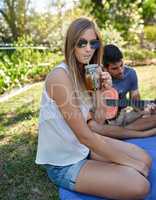 Cooling off this summer. Cropped portrait of an attractive young woman enjoying a few drinks with friends outside in the summer sun.