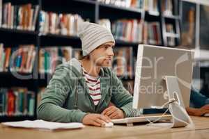 Focused on finals. a young male university student studying in the library.