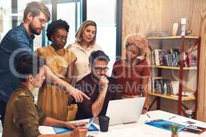 Theyve got the skills and expertise to succeed beyond. a diverse group of businesspeople working together on a laptop in an office.