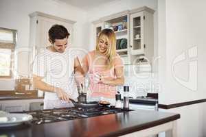 Breakfast, the perfect time to bond. a happy young couple cooking breakfast together at home.