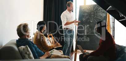 Well meet our targets more efficiently with this plan. a businessman giving a presentation to his colleagues in an office.