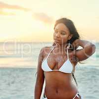 She sustains her beautiful glow with sunlight. a beautiful young woman in a bikini on the beach.