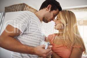 My feelings for you grow deeper everyday. an affectionate young couple enjoying coffee together in the morning at home.