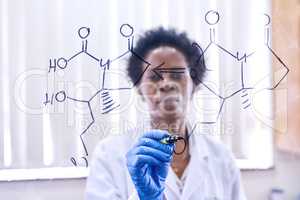 Making groundbreaking discoveries. a female scientist drawing molecular structures on a glass wall in a lab.