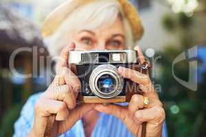 Recording my moments is just a click away. a senior woman taking photographs at home.