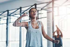 Courage is a decision. a young woman celebrating a victory at the gym.