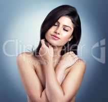 Beautiful mind and oh so fine. Studio shot of a beautiful young woman posing against a blue background.