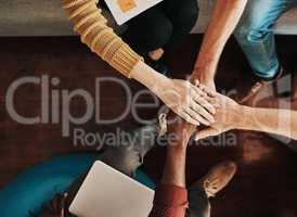 Lets pull together and make great things happen. High angle shot of a group of unrecognizable businesspeople joining their hands together in a huddle.