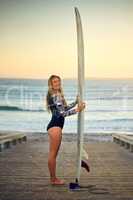 I live to surf. Full length portrait of an attractive young female surfer standing with her surfboard on the beach.