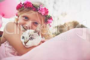 Childhood bliss. a happy little girl holding a kitten and looking at the camera outside in the nature.