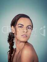 Her hair is on trend. Studio shot of a beautiful young woman posing against a green background.