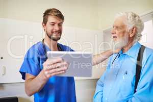 You should be very satisfied with these results. a young doctor explaining a diagnosis to his senior patient by using a tablet.