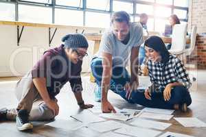 Brimming with big and bold ideas. a group of businesspeople brainstorming on the floor in an office.