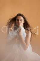 What sparks you. Portrait of a beautiful young woman covering herself with a ballet skirt in studio.