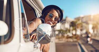 Summers here. Lets go. a happy young woman leaning out of the window during a road trip.