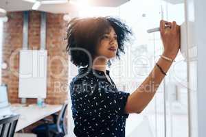 Busy coming up with a winning formula. a young female designer doing some planning on a white board in the office.