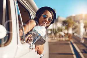 In case you missed the memo, its summer. a happy young woman leaning out of the window during a road trip.