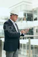 Its important to keep track of the costs of the building. a focused professional male architect standing next to a development site while using a digital tablet inside of a building.