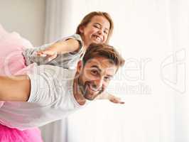 Ill teach her how to sore. Cropped portrait of a handsome young man piggybacking his daughter at home.