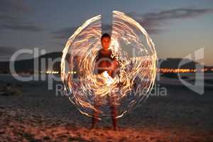 Add a little sparkle to your life. Portrait of a happy young man playing with a sparkler on the beach at sunset.