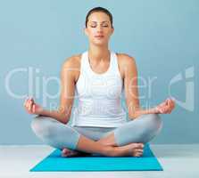 Meditation is good for the mind. Studio shot of a healthy young woman meditating against a blue background.