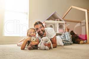 He always has time for his little girl. Portrait of a handsome young man and his daughter playing with stuffed toys on her bedroom floor.