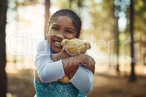 Cuddles for her fluffy little friend. Portrait of a little girl playing in the woods with her teddybear.