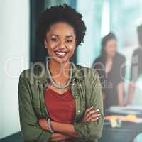 Success forms naturally when you love what you do. Portrait of a businesswoman standing in an office with her colleagues in the background.