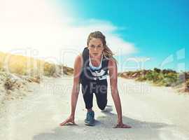 Ready, set, go time to exercise. a sporty young woman getting ready to run outdoors.