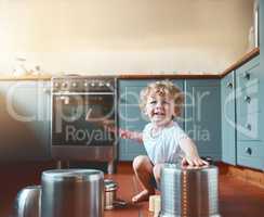Let them be young and noisy. Portrait of an adorable little boy playing with pots in the kitchen.