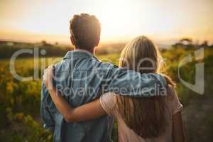 We have really outdone ourselves this time. a young couple walking through their crops while holding each other and looking into the horizon.