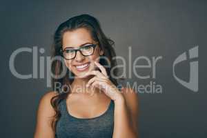 Frame the beauty within. Studio shot of an attractive young woman wearing glasses.