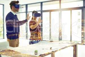 The future is a dream bigger than you would imagine. Multiple exposure shot of two businesspeople wearing VR headsets superimposed over a cityscape.