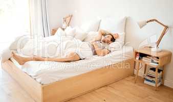 Relaxed man sleeping in bed at home, tired person having dream in bedroom and resting on vacation in house. Exhausted male relaxing at hotel, looking cozy in the morning and sleepy on soft sheets