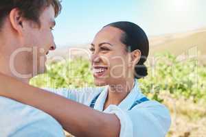 Love, countryside and couple smile, loving and bond together on a sunny wine farm field and nature agriculture. Interracial, green and happy man and woman travel to a holiday vacation trip in summer