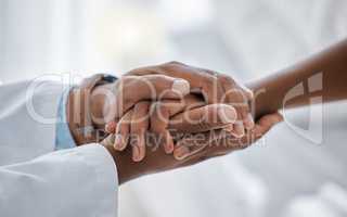 Support, trust and hospital care with a doctor and patient holding hands, sharing bad news of a cancer diagnosis. Kind doctor offering a loving gesture to a sick person during a health crisis