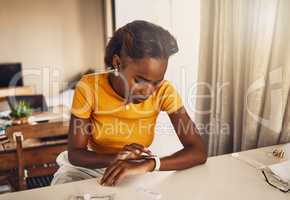 Young, worried and stressed black woman waiting for the results of covid test. African American woman looking at the time on a smart watch and anxious or fearful about her medical and health status