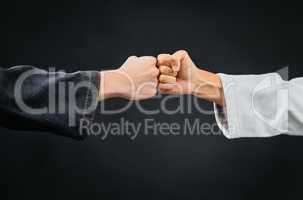 Teamwork, respect and discipline with hands fist bumping before a fight, match or mma competition. Closeup of two athletes greeting before combat sport and self defense against a black background