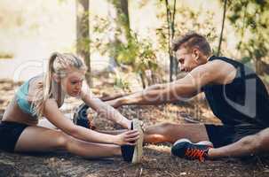Couples that train together remain together. a young couple stretching together outdoors.