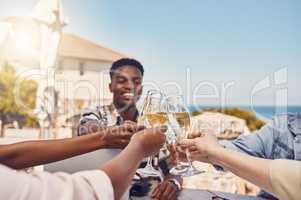 Celebration, alcohol and friends toast with wine at an outdoor restaurant, happy and having fun. Young diverse people gathering to celebrate freedom, birthday, friendship or good news with cheers