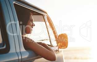 Summertime is even better when youre traveling. an attractive young woman enjoying a road trip.