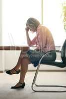 Shes having a hard time focusing at work. a businesswoman looking stressed out while working in an office.