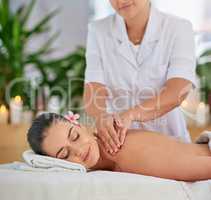Today is for being pampered. an attractive young woman enjoying a back massage at a spa.